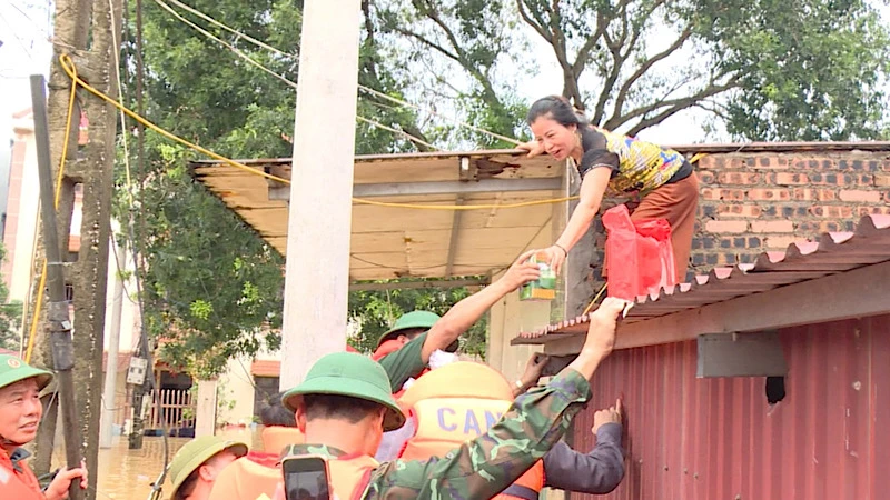 Hỗ trợ người dân đang bị nước lũ cô lập tại xã Hòa Tiến, huyện Yên Phong.