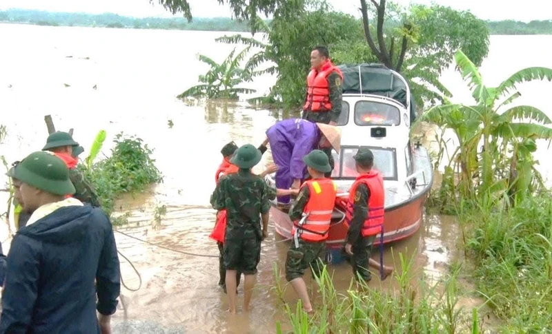 Các đơn vị vũ trang di dời người dân khu vực bãi bồi Phú Động vào nơi an toàn.