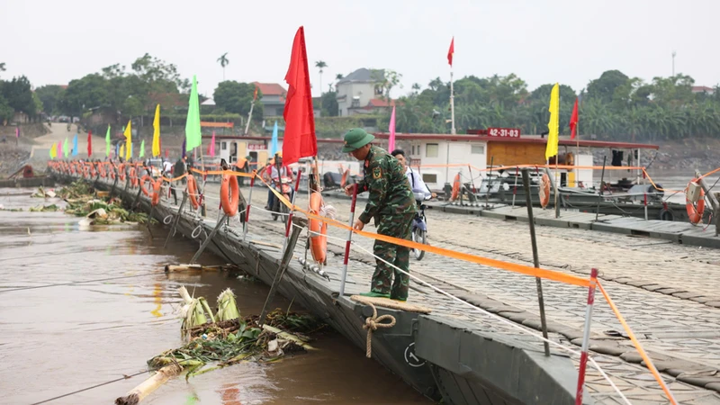 Nước từ thượng nguồn đổ về kéo theo nhiều cây cối khiến cầu phao phải đóng để bảo đảm an toàn.