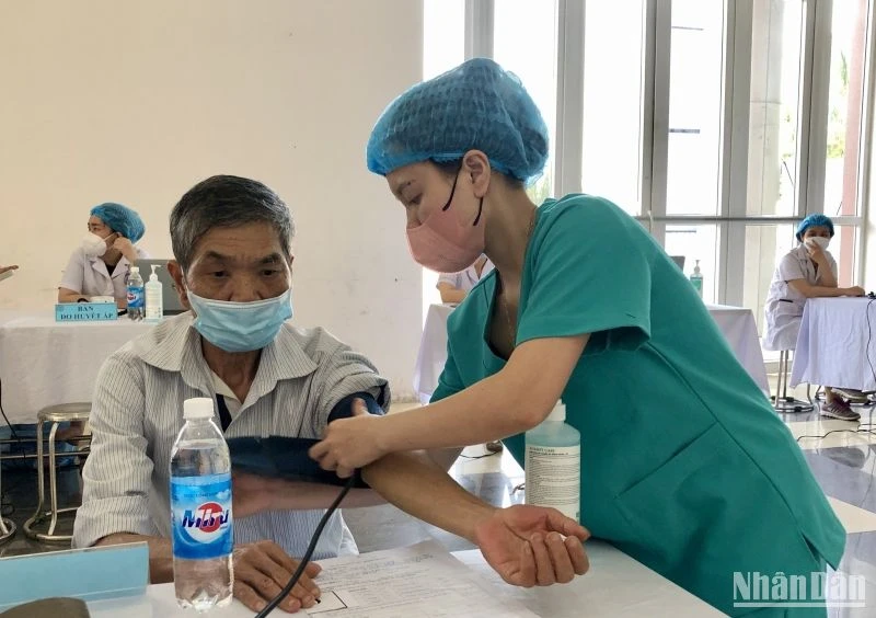 Các cán bộ y, bác sĩ thăm khám sức khỏe cho người dân trên địa bàn huyện Mê Linh.