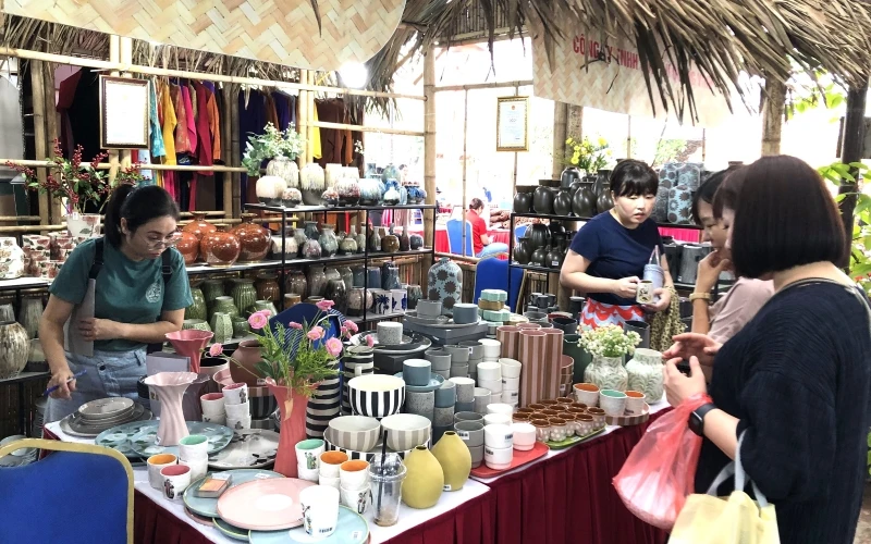 Khách tham quan mua sắm các sản phẩm hàng lưu niệm của Hà Nội.
