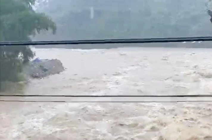 Mưa lớn, nước sông tại miền núi huyện Nam Trà My chảy xiết, người dân dễ bị cuốn trôi khi qua sông.
