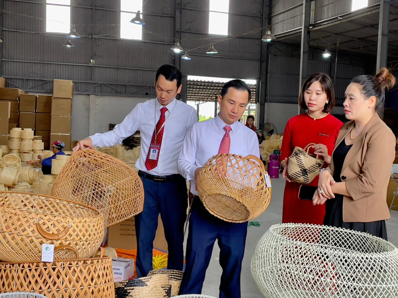 Bà Đặng Thị Dung (ngoài cùng bên phải) giới thiệu sản phẩm mây tre đan của doanh nghiệp với cán bộ Agribank.
