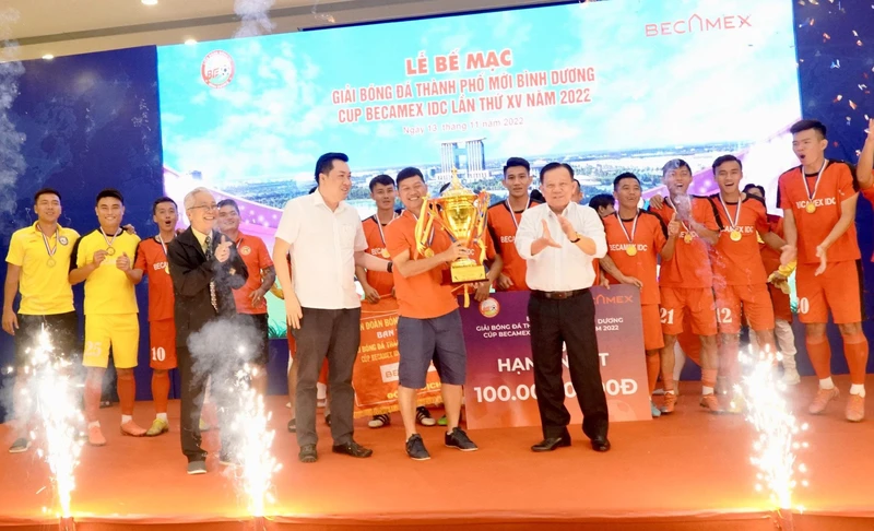 Chủ tịch Hội đồng quản trị Tổng Công ty Becamex IDC Nguyễn Văn Hùng (bên phải, hàng đầu) trao Cúp vô địch cho đội Bambo FC.