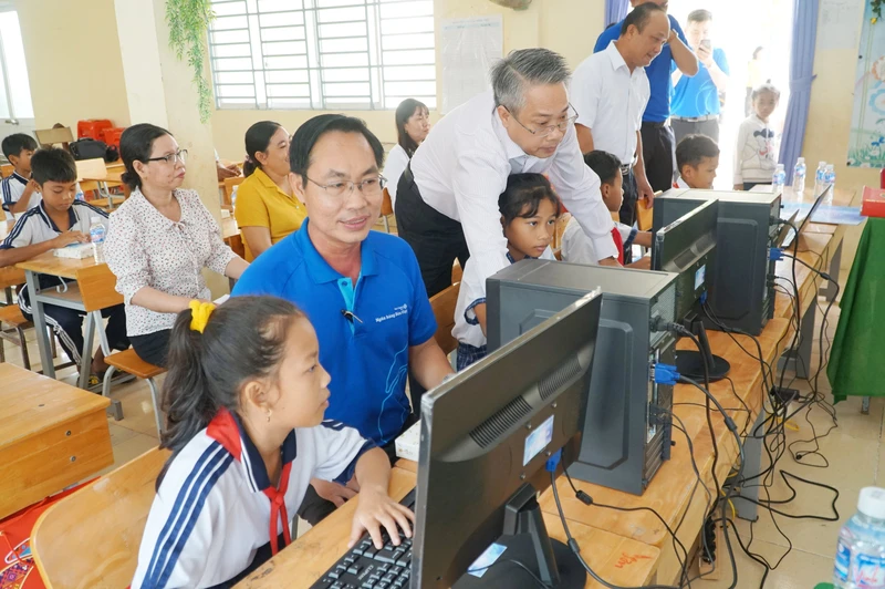 Cán bộ Ngân hàng Bản Việt hướng dẫn các em học sinh dân tộc Khmer sử dụng máy vi tính.