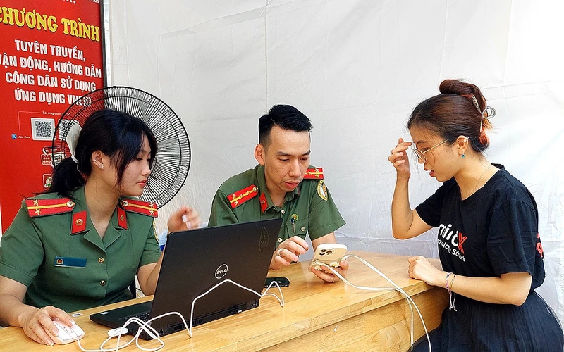 Cán bộ, chiến sĩ trẻ lực lượng Công an Thành phố Hà Nội hỗ trợ, hướng dẫn người dân đăng ký, kích hoạt định danh điện tử. 