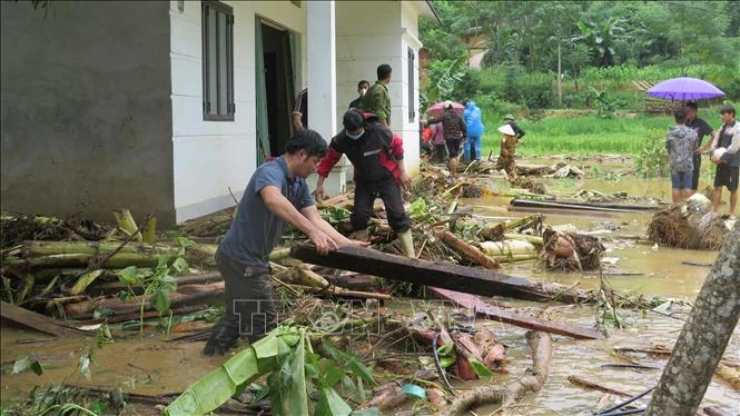 Người dân địa phương nỗ lực tìm người thân bị nạn sau lũ dữ. Ảnh: Hồng Ninh/TTXVN