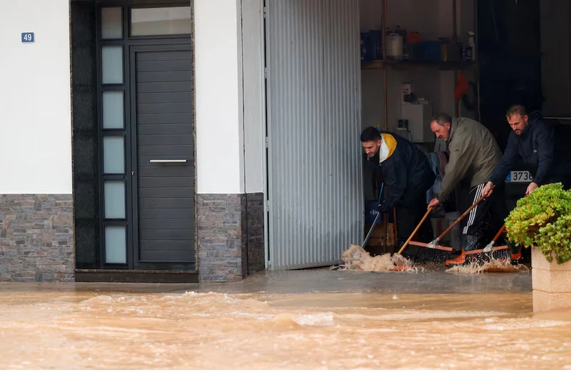 Người dân ngăn chặn nước vào nhà. Ảnh: Reuters.