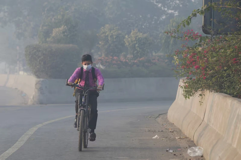 Học sinh đạp xe đến trường giữa màn sương mù dày đặc ở Lahore, Pakistan. Ảnh: Reuters