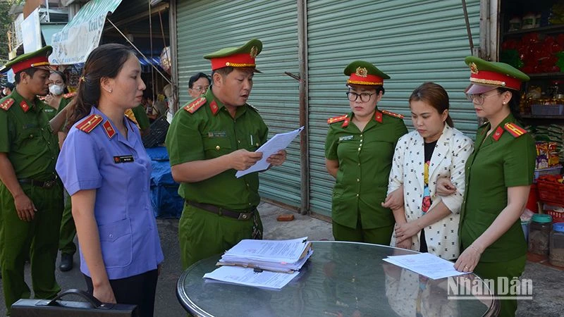 Cơ quan cảnh sát điều tra Công an thành phố Phan Thiết đọc Quyết định khởi tố bị can đối với Ngô Thị Loan Chi (áo trắng hoa), về tội “Lừa đảo chiếm đoạt tài sản”.
