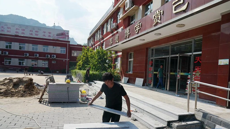 Công nhân gấp rút tu sửa trường học ở quận Môn Đầu Câu, thành phố Bắc Kinh, Trung Quốc. (Ảnh: Tân Hoa Xã)