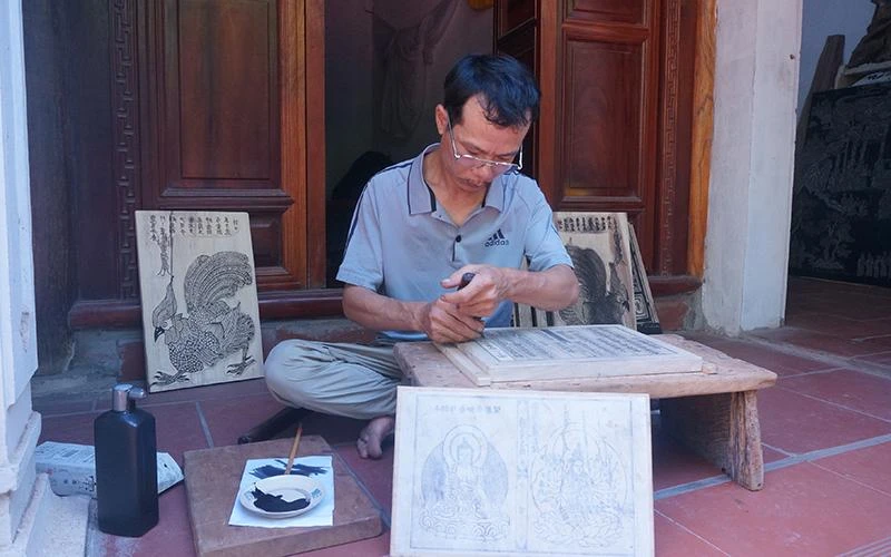 Anh Nguyễn Văn Thạo đang khắc mộc bản.
