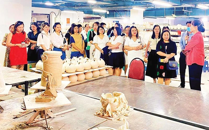 Chủ tịch Hiệp hội Thủ công mỹ nghệ và làng nghề Hà Nội Hà Thị Vinh giới thiệu với khách tham quan về gốm Bát Tràng (huyện Gia Lâm).