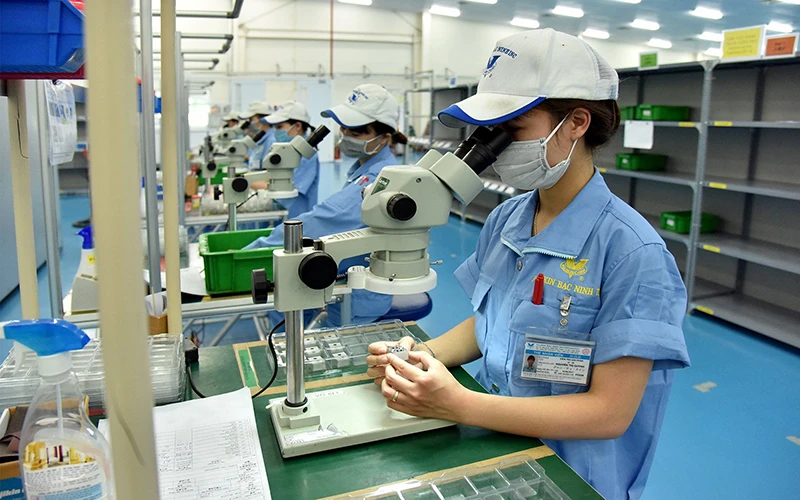 Công nhân làm việc tại dây chuyền sản xuất linh kiện cơ khí siêu chính xác tại công ty TNHH Fujikin Bắc Ninh (Khu công nghiệp VSIP Bắc Ninh). (Ảnh ANH SƠN)