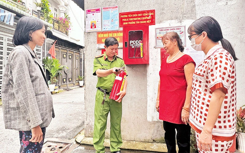 Công an khu vực phường Tân Chánh Hiệp (Quận 12) hướng dẫn người dân sử dụng bình chữa cháy.