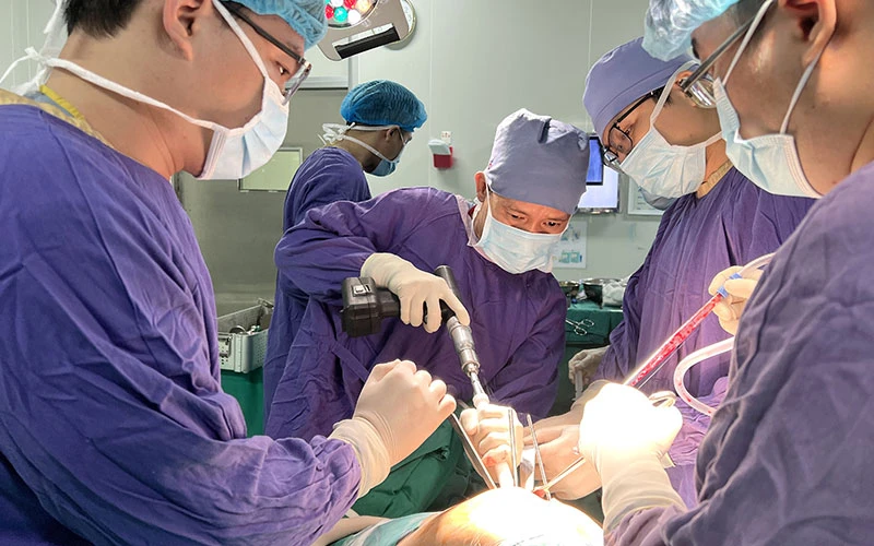 Các bác sĩ Bệnh viện Hữu nghị Việt Đức thực hiện ca phẫu thuật thay khớp háng cho người bệnh. (Ảnh NGUYỄN THẮNG) 