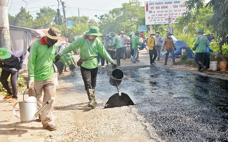 Trải nhựa thi công một đoạn đường nông thôn xuống cấp ở xã Mỹ Hội Đông.