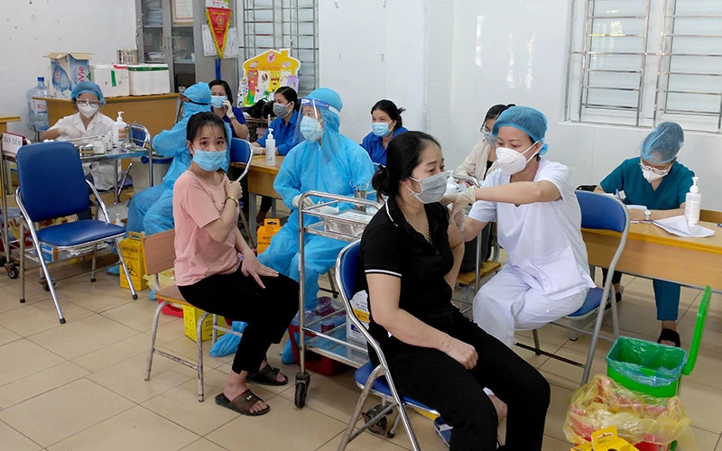 Nhân viên y tế quận Hoàng Mai (Hà Nội) tiêm vắc-xin phòng Covid-19 cho người dân phường Vĩnh Hưng. (Ảnh THANH TRÚC) 