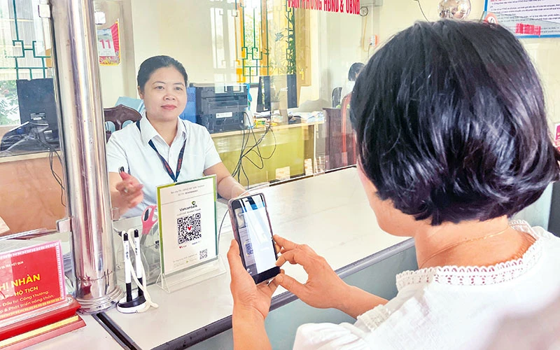 Người dân xã Tân Thành (huyện Kim Sơn, tỉnh Ninh Bình) thanh toán lệ phí qua ứng dụng thanh toán điện tử trên điện thoại di động.