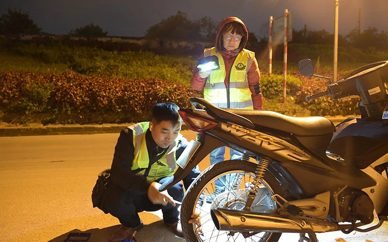 Thành viên Đội Cứu hộ Hà Nội vá xe giúp người đi đường trong đêm.