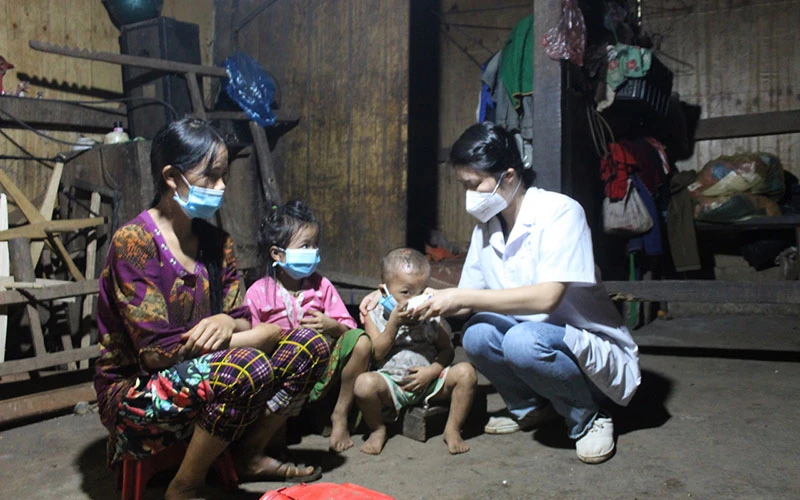 Cán bộ y tế hướng dẫn người dân thôn Phe Phà, xã Lũng Hồ, huyện Yên Minh, Hà Giang uống thuốc điều trị, phòng bệnh bạch hầu.