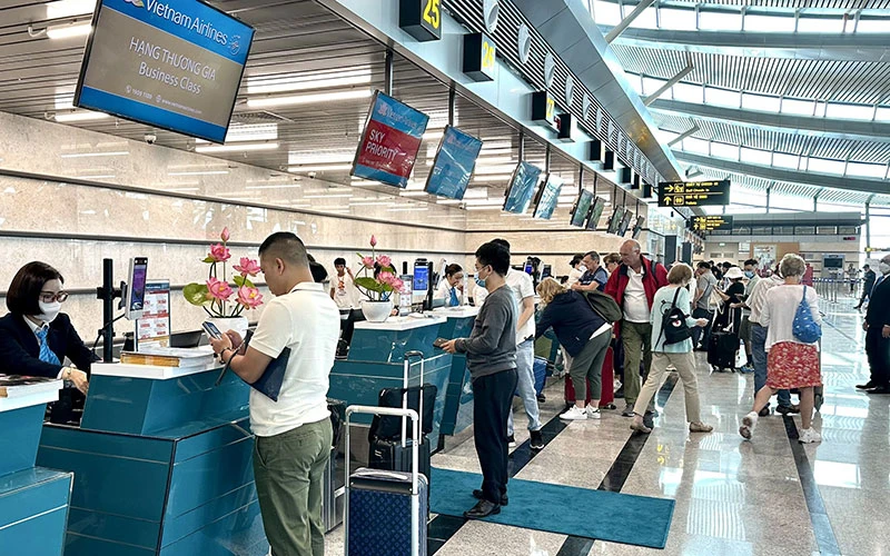 Hành khách làm thủ tục tại quầy của Hãng hàng không quốc gia Việt Nam. (Ảnh BẢO NGÂN)