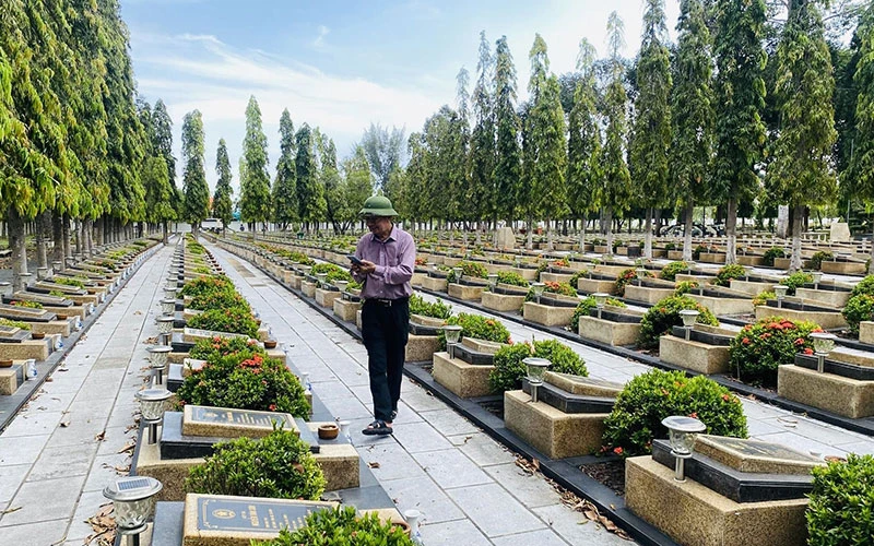Thầy giáo Nguyễn Sỹ Hồ chụp ảnh bia mộ tại các nghĩa trang liệt sĩ, giúp thân nhân tìm mộ liệt sĩ. (Ảnh NVCC)