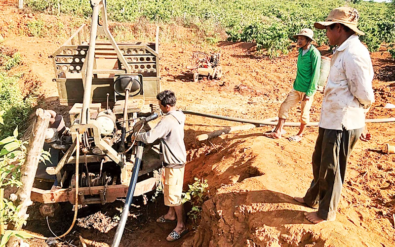 Người dân xã Ia Sao, huyện Ia Grai lắp đặt máy bơm để tưới nước cho cây cà-phê. 