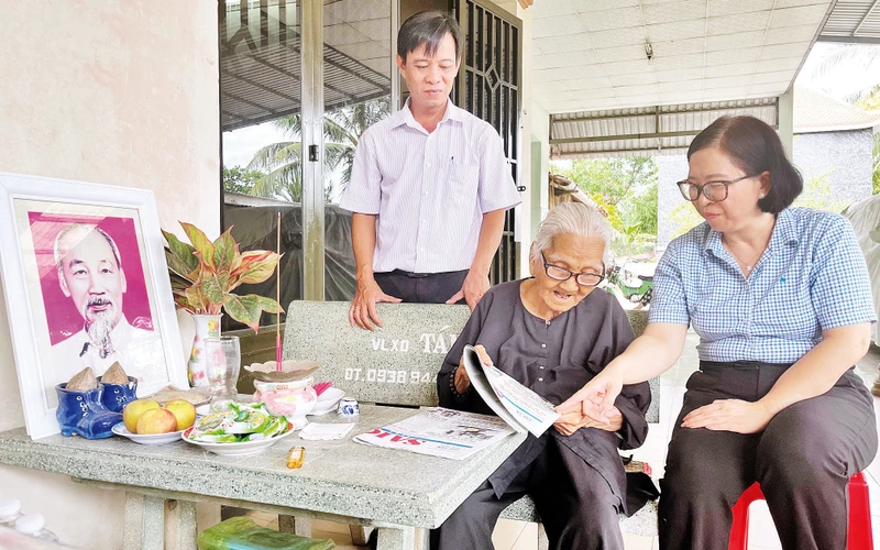 Bí thư Đảng ủy thị trấn Tân Túc Trần Thị Hải Yến (phải) và Bí thư Chi bộ Khu phố 9 Phạm Quang Vũ thăm hỏi đồng chí Nguyễn Thị Mười.