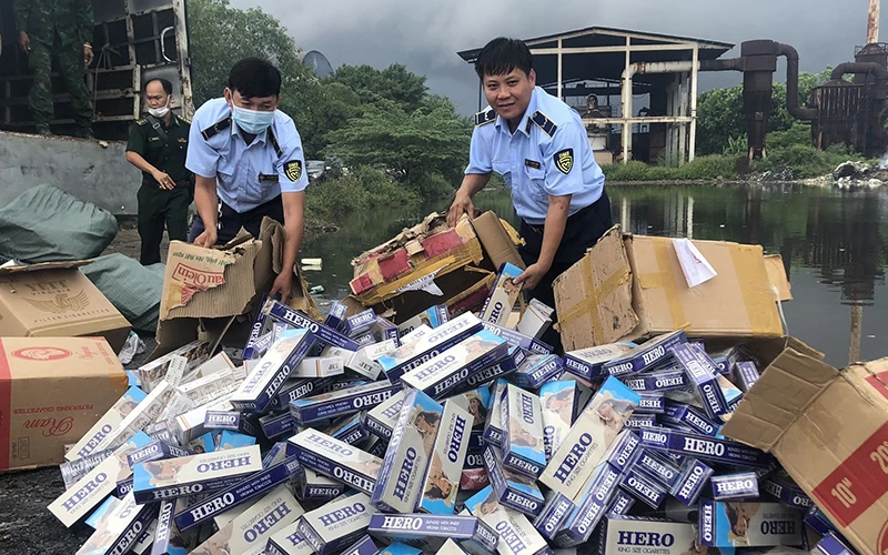 Lực lượng Quản lý thị trường tỉnh Kiên Giang tiêu hủy thuốc lá nhập lậu thu giữ được. (Ảnh HỒNG CHỨC)