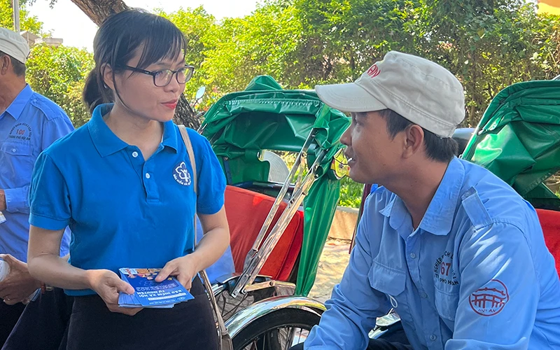 Cán bộ Bảo hiểm xã hội thành phố Hội An tuyên truyền chính sách BHXH tự nguyện cho người lao động của Nghiệp đoàn xích lô Hội An (tỉnh Quảng Nam).