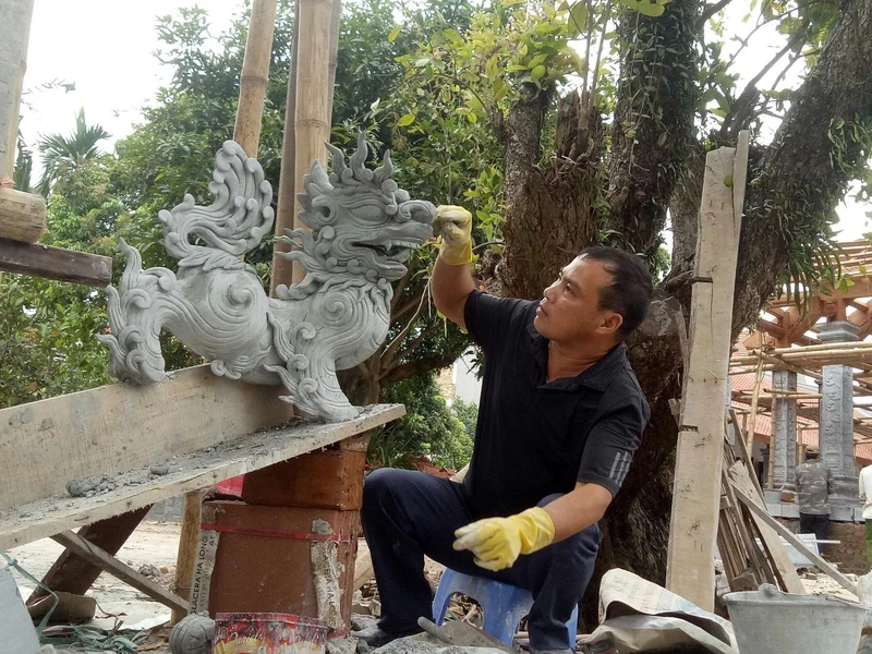 Nghệ nhân Nguyễn Đức Thủy đang tạo tác linh vật.