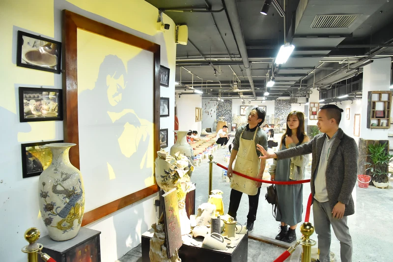 Nghệ nhân Bùi Văn Tự giới thiệu với khách tham quan về tác phẩm Nỗi suy tư nghề gốm được trưng bày tại Trung tâm Tinh hoa làng nghề Việt. (Ảnh: THỦY NGUYÊN)