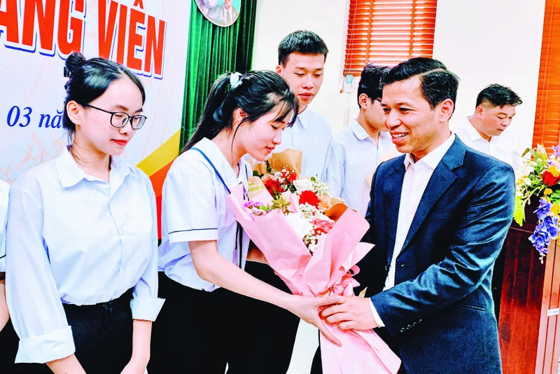 Phó Trưởng ban Tổ chức Thành ủy Hải Phòng Nguyễn Hồng Vinh tặng hoa các đảng viên mới là học sinh lớp 12 Trường THPT chuyên Trần Phú được kết nạp Đảng.