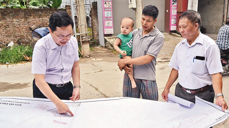 Cán bộ Trung tâm Phát triển quỹ đất huyện Mê Linh khảo sát thực địa công tác giải phóng mặt bằng đường vành đai 4 đoạn qua xóm Trại A, thôn Khuê Ngoại, xã Văn Khê. (Ảnh: DUY LINH)