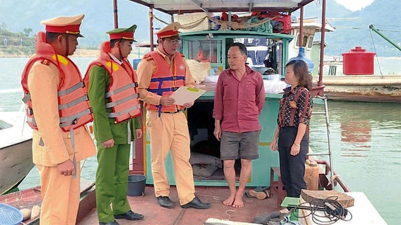 Cán bộ Đội Cảnh sát giao thông đường thủy tuyên truyền chủ phương tiện trên địa bàn thị xã Mường Lay biện pháp bảo đảm an toàn giao thông đường thủy.
