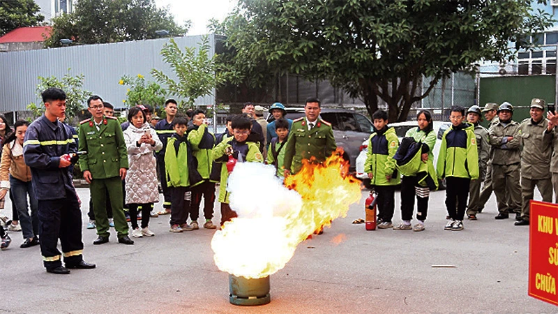 Học sinh và người dân TP Lạng Sơn trải nghiệm, thực hành sử dụng bình chữa cháy. (Ảnh: HOÀNG HUẤN)