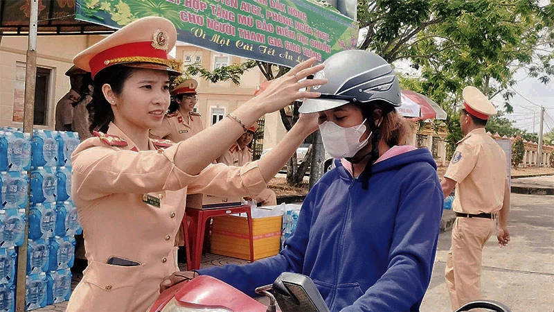 Lực lượng Cảnh sát giao thông Công an tỉnh Đắk Nông trao mũ bảo hiểm tặng người dân trên đường về quê đón Tết.
