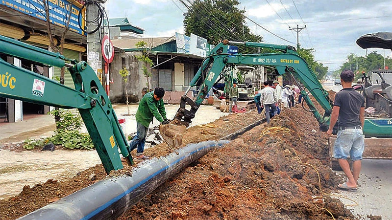 Thi công mạng lưới nước sạch tại huyện Ba Vì. (Ảnh: KIM NHUỆ)