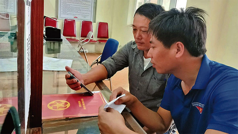 Đoàn viên thanh niên xã Minh Tân (huyện Phú Xuyên) hướng dẫn người dân thực hiện thủ tục hành chính online.