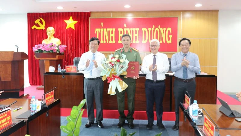 Thường trực Tỉnh ủy Bình Dương trao Quyết định của Ban Bí thư Trung ương Đảng và tặng hoa cho Đại tá Tạ Văn Đẹp.