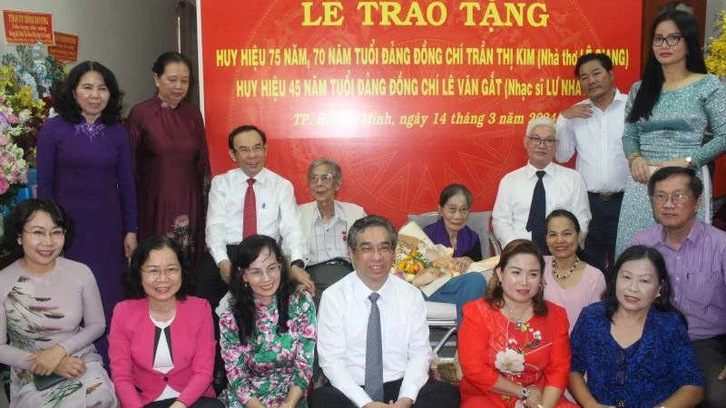 Đồng chí Nguyễn Văn Nên, Ủy viên Bộ Chính trị, Bí thư Thành ủy Thành phố Hồ Chí Minh và các đại biểu chụp hình lưu niệm với nhà thơ Lê Giang và nhạc sĩ Lư Nhất Vũ.
