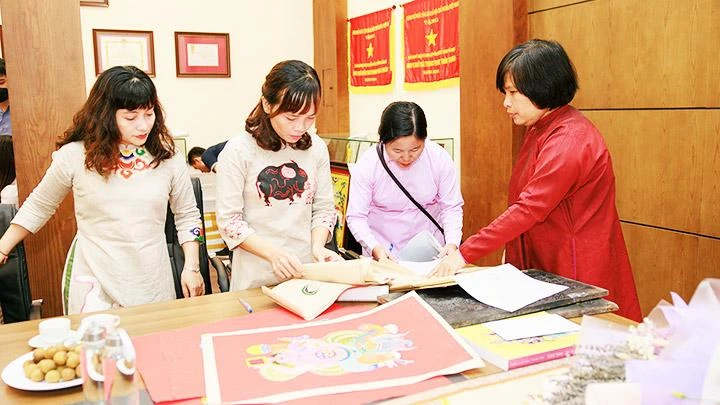 Nhà nghiên cứu, sưu tầm Nguyễn Thị Thu Hòa (ngoài cùng, bên phải) giới thiệu với người xem về tranh dân gian Kim Hoàng.