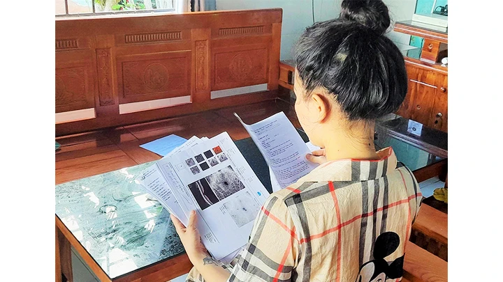 Chị Trần Thị Vy cùng với hồ sơ bệnh án tai biến do tiêm nâng mũi.