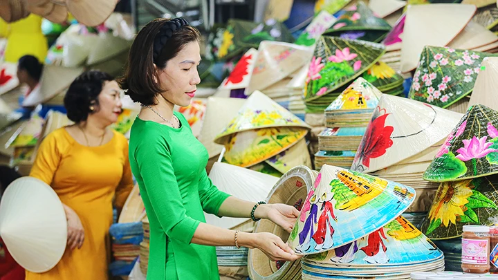 Hình ảnh tiểu thương mặc áo dài bán hàng gây ấn tượng với du khách khi ghé chợ Đông Ba.