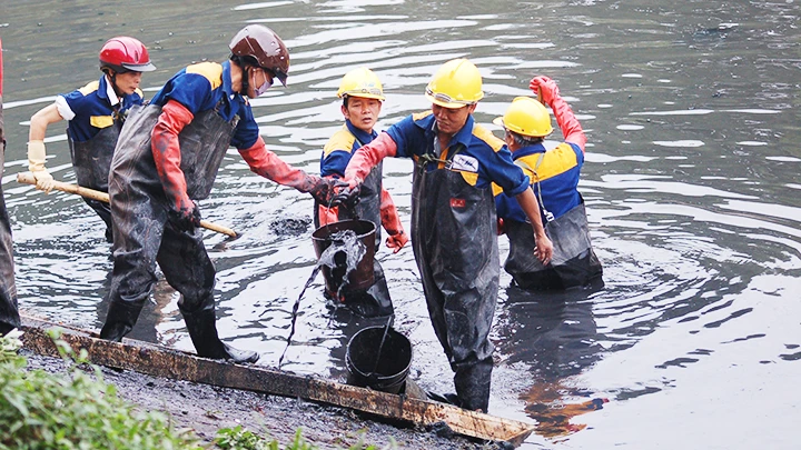 Vớt rác bùn khơi thông dòng chảy trên sông Tô Lịch. Ảnh: NGUYỄN MINH