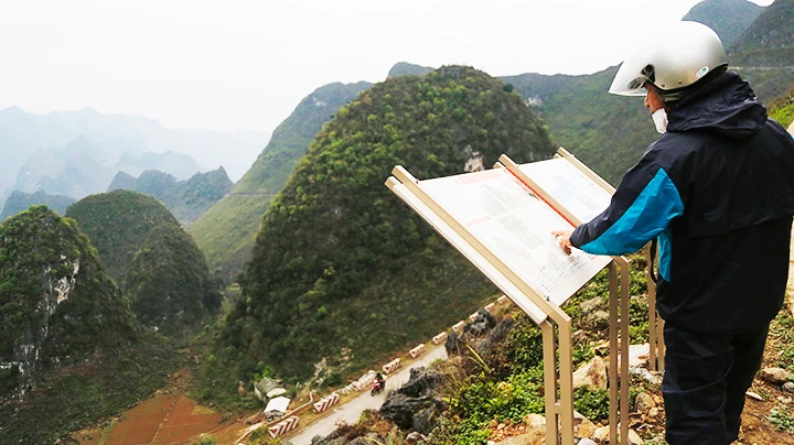 Du khách xem thông tin giới thiệu về tuyến đi bộ Vách đá trắng, sản phẩm du lịch mới trên đèo Mã Pì Lèng (Hà Giang). Ảnh: K.MINH