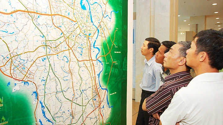Người dân xem sơ đồ hệ thống giao thông tại Triển lãm quy hoạch Thủ đô đến năm 2030 tầm nhìn đến 2050. Ảnh: NGUYỄN MINH