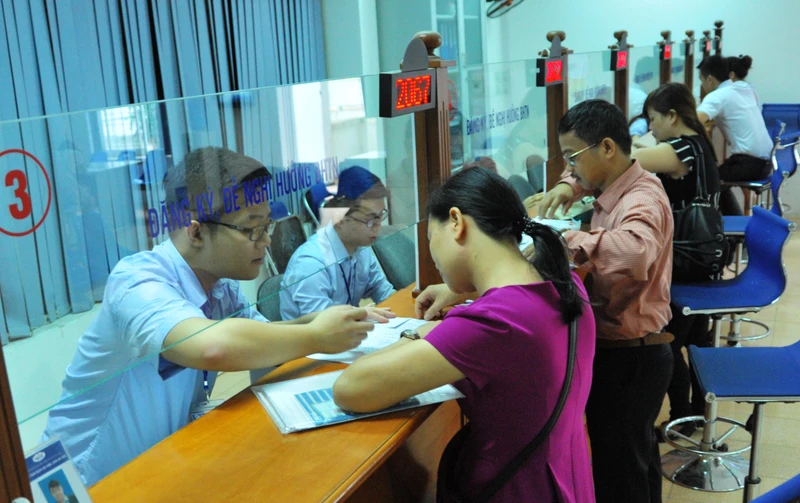 Người lao động làm thủ tục bảo hiểm xã hội tại Trung tâm giới thiệu việc làm Hà Nội. Ảnh: BẮC SƠN