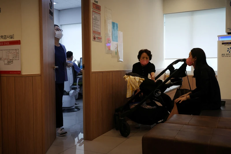Một gia đình chờ bên ngoài phòng khám nhi ở Hàn Quốc. Ảnh: REUTERS